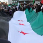 Large Syrian revolutionary flag at the central point of the rally