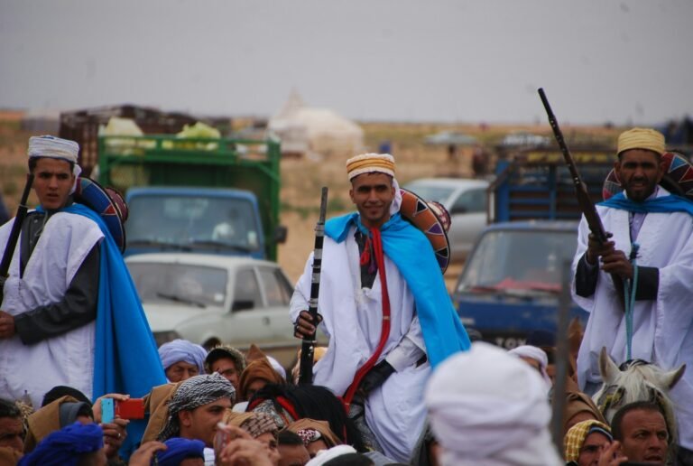people holding rifle by a crowd of sitting people