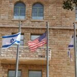 a group of flags flying in front of a building