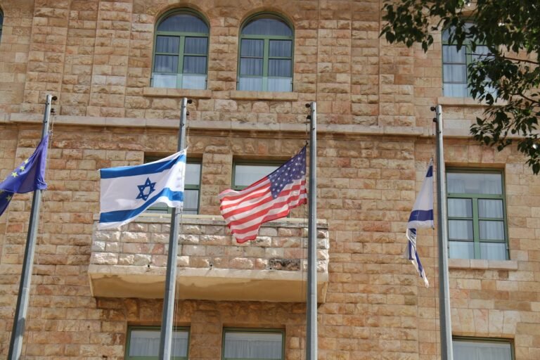 a group of flags flying in front of a building