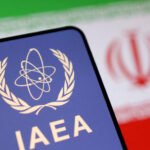 FILE PHOTO: Illustration shows International Atomic Energy Agency (IAEA) logo and Iranian flag