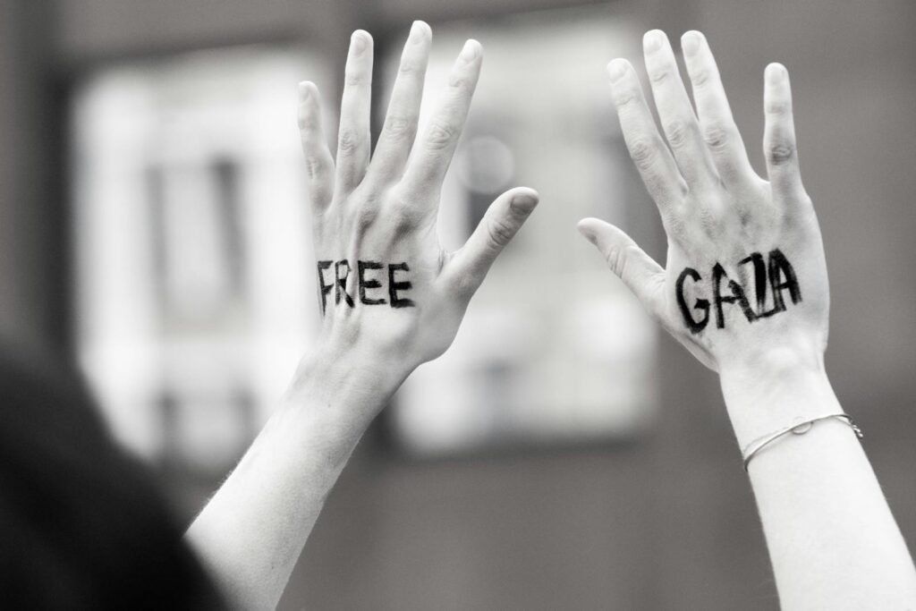 Hands raised with 'Free Gaza' message during a protest, symbolic and expressive.