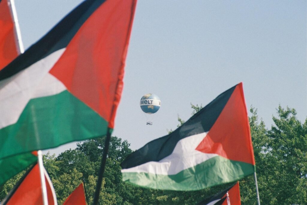 Palestinian flags with a Welt hot air balloon in Berlin, symbolizing awareness and protest.