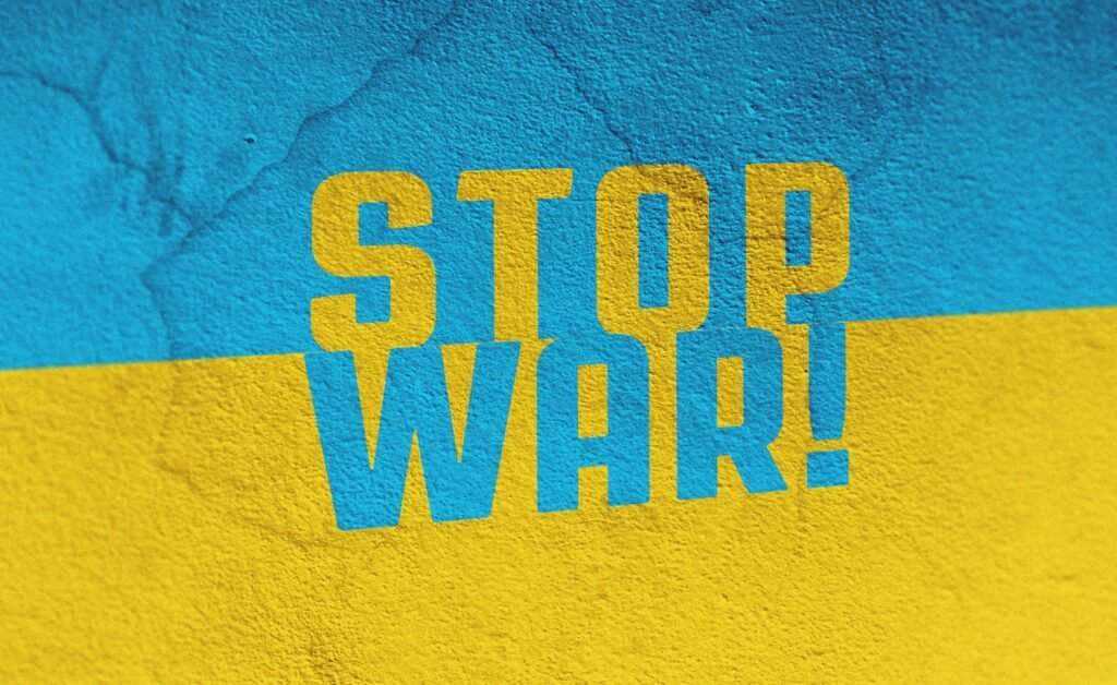 a blue and yellow wall with the words stop war painted on it